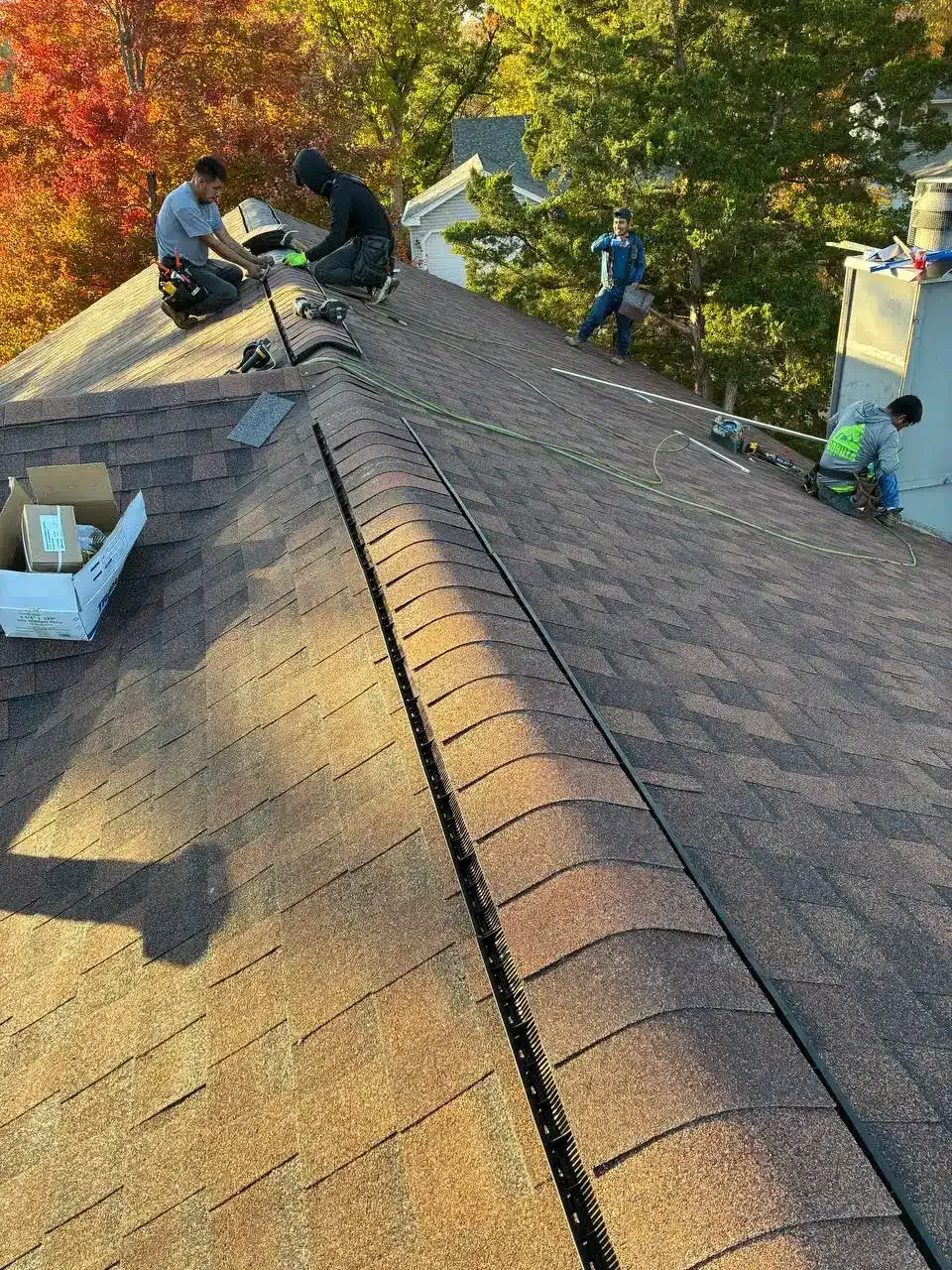 Gorilla Roofing crew installing asphalt shingles and ridge vent on a St. Louis home