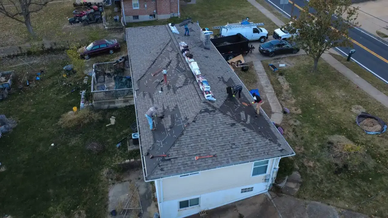Aerial drone view of roofing crew replacing shingles on a residential home in St. Louis, MO