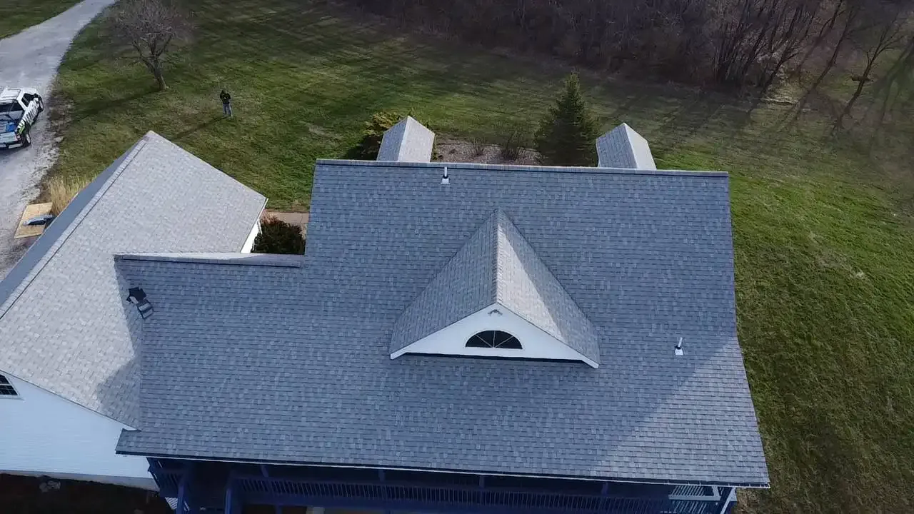 Aerial drone view of newly installed gray asphalt shingle roof on large home in St. Louis, MO