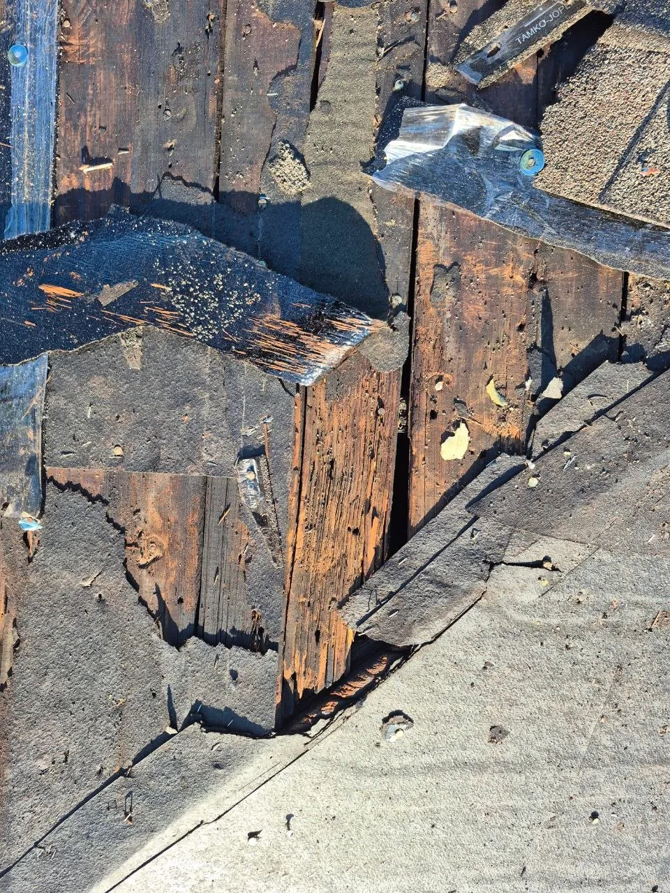 Severely rotted and deteriorated roof decking with damaged asphalt shingles exposing broken wooden boards in St. Louis