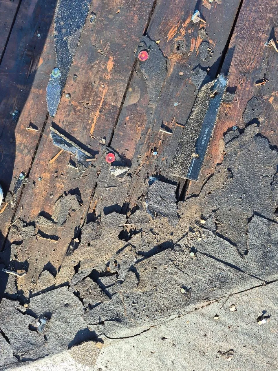 Severely damaged roof decking with deteriorated shingles, rotted wood, and exposed underlayment in St. Louis, MO