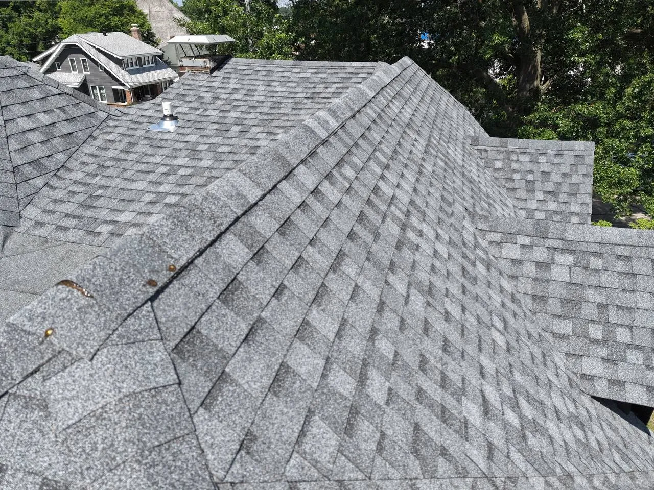 Aerial view of a newly installed gray asphalt shingle roof with multiple hips and valleys on a St. Louis home.