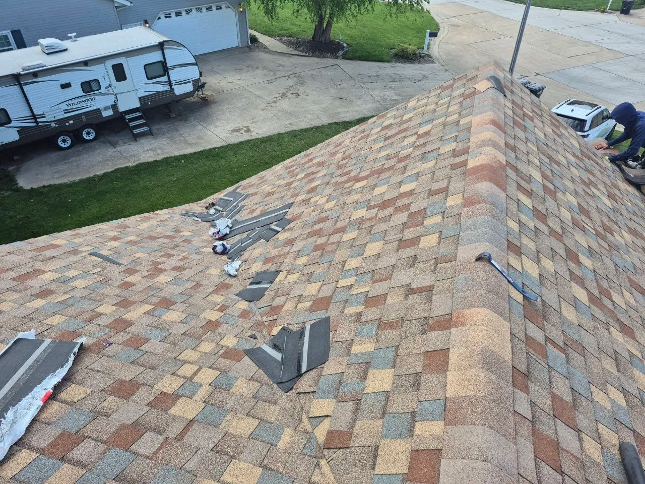 Storm-damaged roof with blown-off shingles scattered across a residential roof in Chesterfield, MO