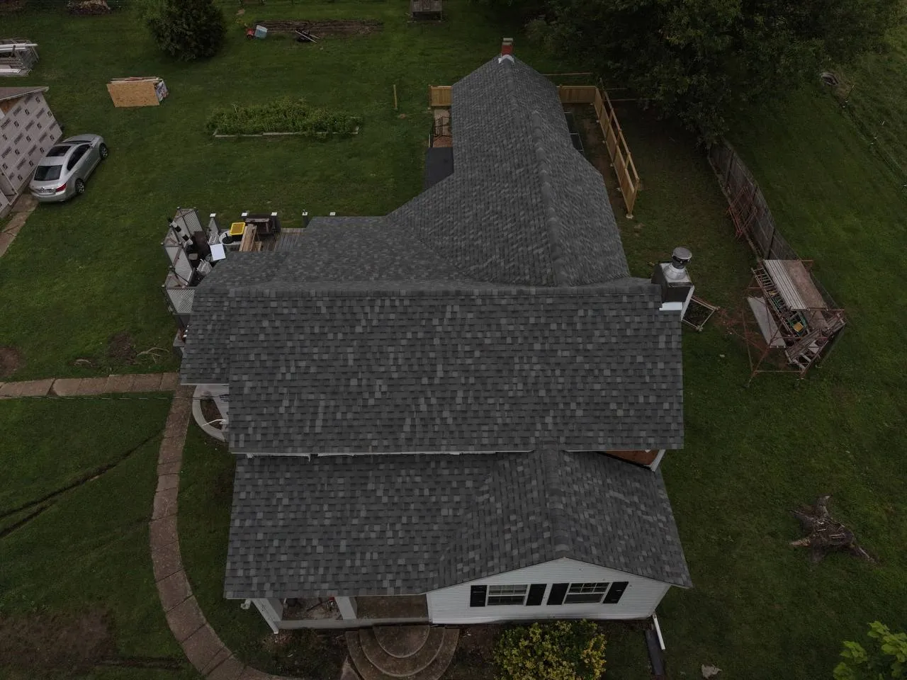 Aerial drone view of a residential home with newly installed dark gray asphalt shingle roof in St. Louis, MO.