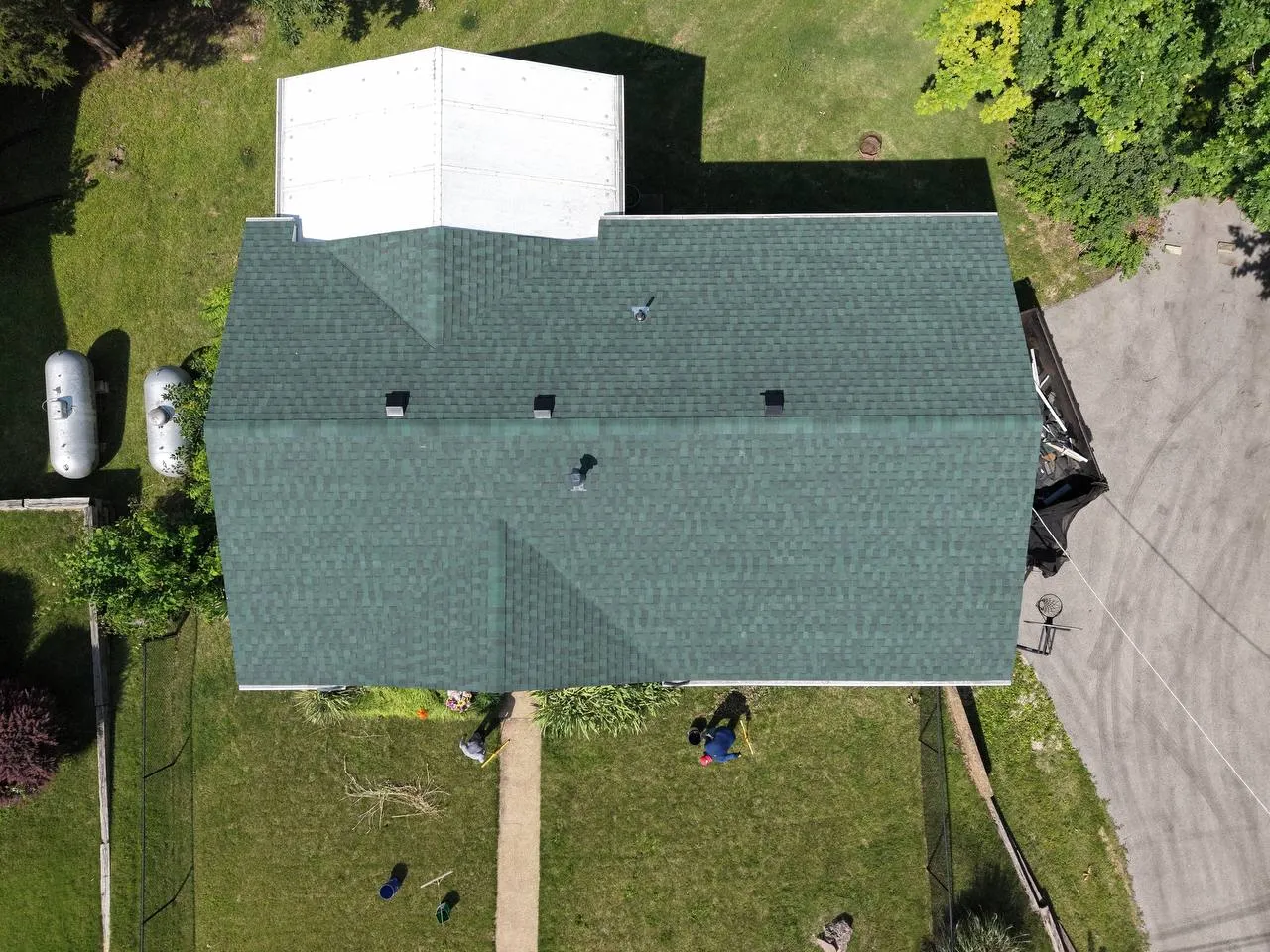 Aerial drone view of a completed green asphalt shingle roof replacement on a residential home in St. Louis, MO.