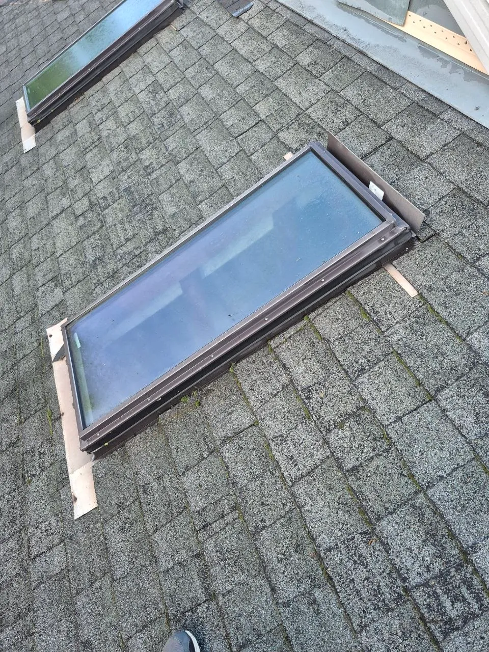New skylight unit staged on asphalt shingle roof during installation in St. Louis, MO