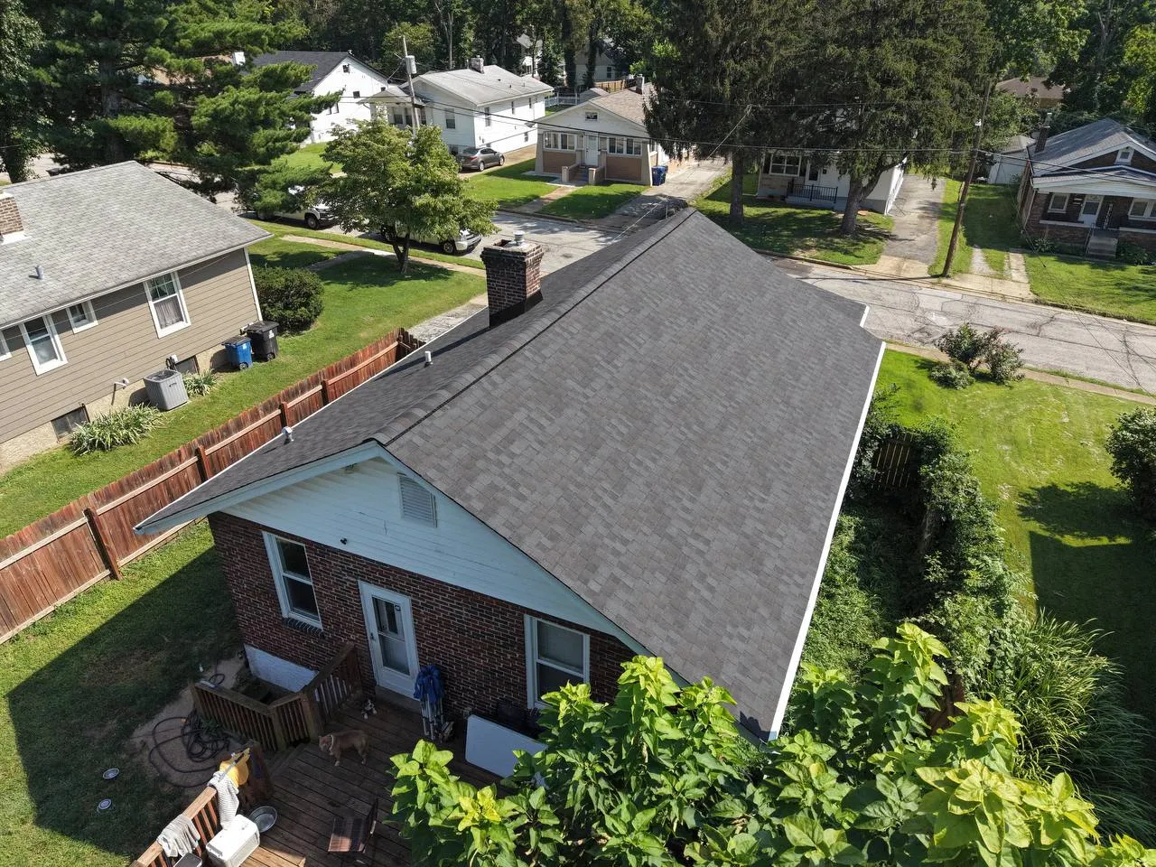 Aerial drone view of a newly installed dark gray asphalt shingle roof on a brick home in St. Louis, MO