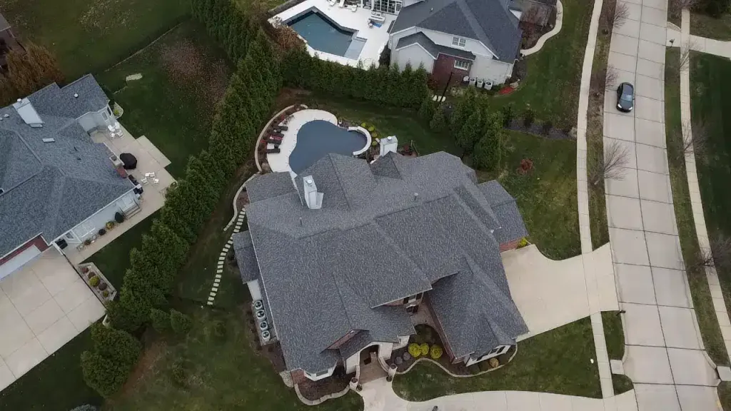 Aerial view of a residential home with visible storm damage to the roof