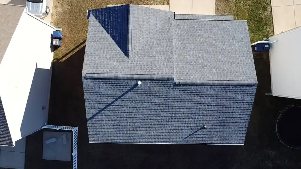 Close-up aerial view of a residential shingle roof being inspected for hail damage