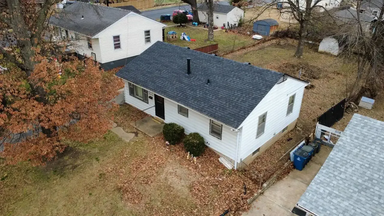 Aerial drone view of completed asphalt shingle roof replacement on white ranch-style home in St. Louis, MO